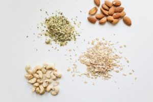 pexels-photo-4110186-4110186 Top view of almonds, cashews, oats, and hemp seeds on white background.